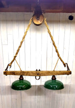 Load image into Gallery viewer, Suspended from a single wheel barn pulley by a vintage hemp rope, two barn shade with Edison lights attached to a horse yoke make up this rustic chandelier. The barn shades display their original green paint, and timeworn patina. Dimensions are 38 in W, 44 in H. Lights are not illuminated.