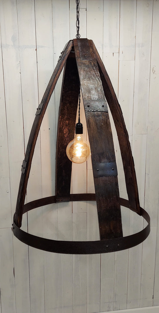 Whiskey Barrel Chandelier with oversized Edison Bulb  Constructed with four barrel staves, joined at the top by 4-way crossed barrel ring metal; secured at the bottom by full barrel ring 2-ring barrel ring accents evenly distanced between top and bottom on all four staves Chandelier has a three foot hanging chain Dimensions : 33in H, 25in diameter. Light is illuminated.