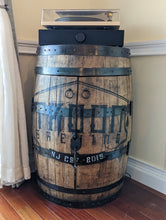 Load image into Gallery viewer, Commissioned whiskey barrel displayed in customer's home- frontal view with doors closed.
