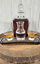 Load image into Gallery viewer, A whiskey barrel stave coaster sporting 3 indents, with a Glencairn glass at each end, and a small carafe in the middle. The coaster sits on a barrel top. A whiskey decanter sits behind the coaster and the glasses hold whiskey and water.