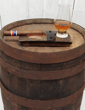 Load image into Gallery viewer, Showing a cigar and whiskey glass, this genuine whiskey barrel stave, accented with a rustic barrel ring with a felt bottomed Glencairn Glass indent, and a copper bottomed cigar receptacle, measures 8” L x 4” W.