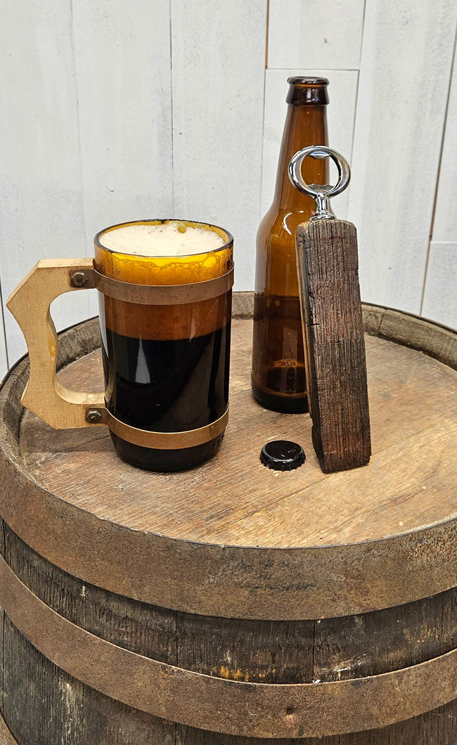 Whiskey Barrel Stave Bottle Opener on top of a whiskey barrel next to a poured mug of ale.  Opener is leaning against a empty beer bottle.