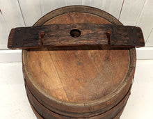 Load image into Gallery viewer, A wine barrel stave with center hole for hanging over the neck of a wine bottle, and left-right cutouts for stemmed glasses, displayed on a wooden barrel top.
